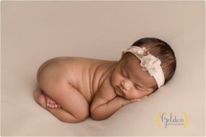 baby girl laying down on belly in studio