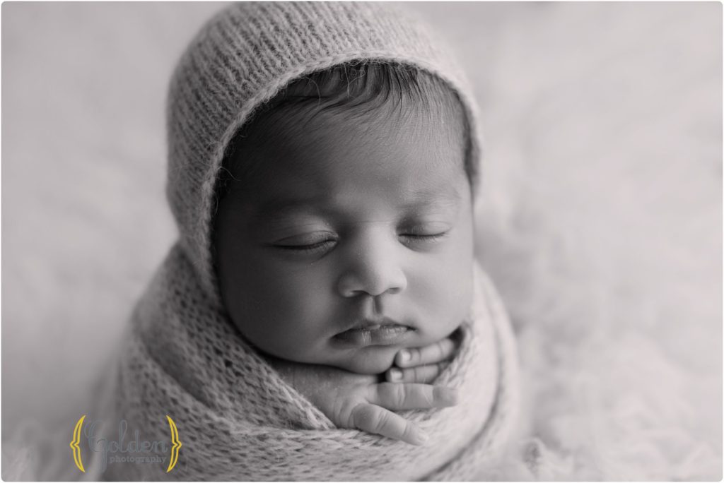 black and white photo of baby girl wearing a bonnet