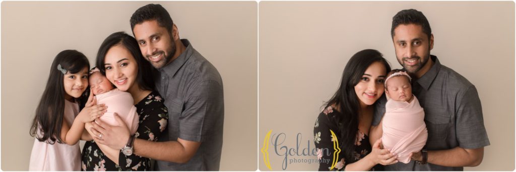 family of four with newborn baby girl in studio