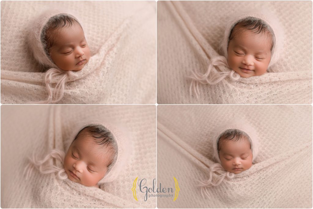 baby tucked in pink blanket smiling