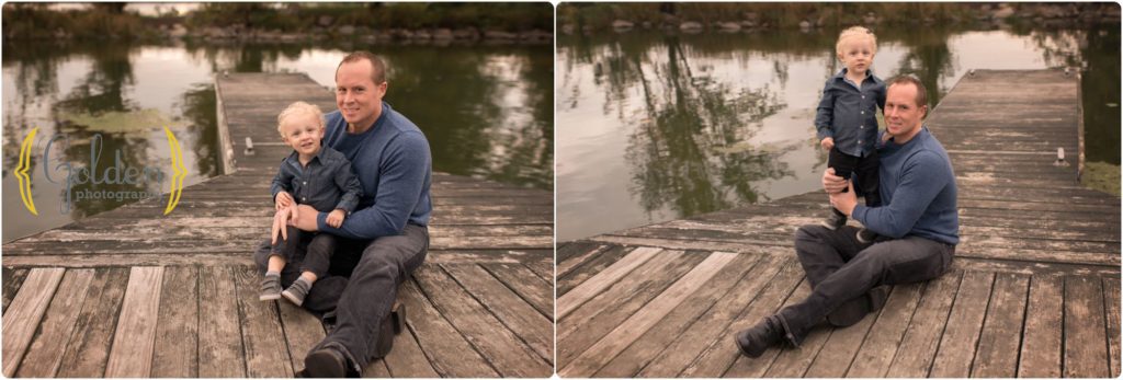 little boy sitting with dad on docks near water