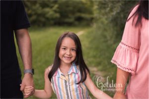 girl holding mom and dad's hands