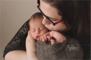 new mom kissing newborn baby boy