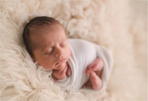 swaddled baby boy on white rug in Chicago IL