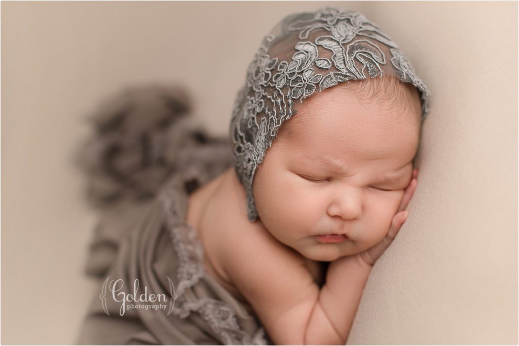 baby girl wearing grey bonnet in newborn photography studio in northwest Chicago suburbs