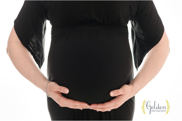 pregnant belly and hands posed in photography studio