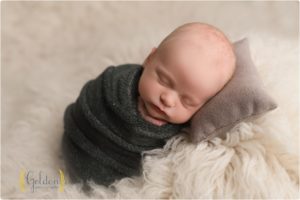 baby wrapped and asleep on pillow in Chicago IL photo studio