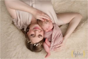 mom laying down with newborn baby girl