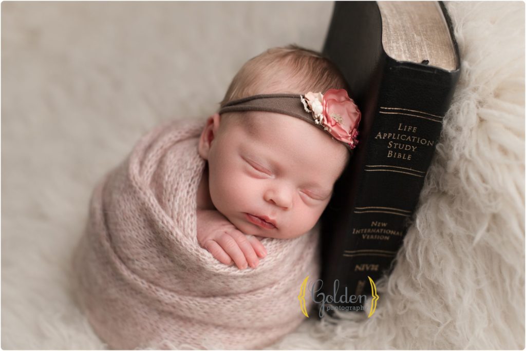 baby girl swaddled and laying on Bible in Lake Zurich IL photography studio