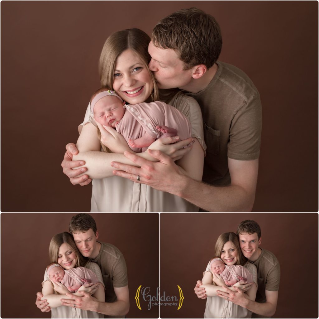 family of three holding baby girl in photo studio near Palatine