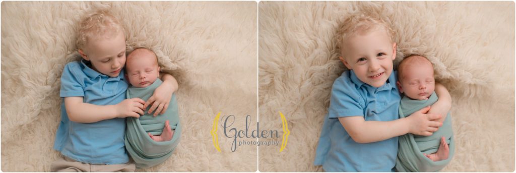 big brother hugging newborn baby in photo studio near Libertyville IL