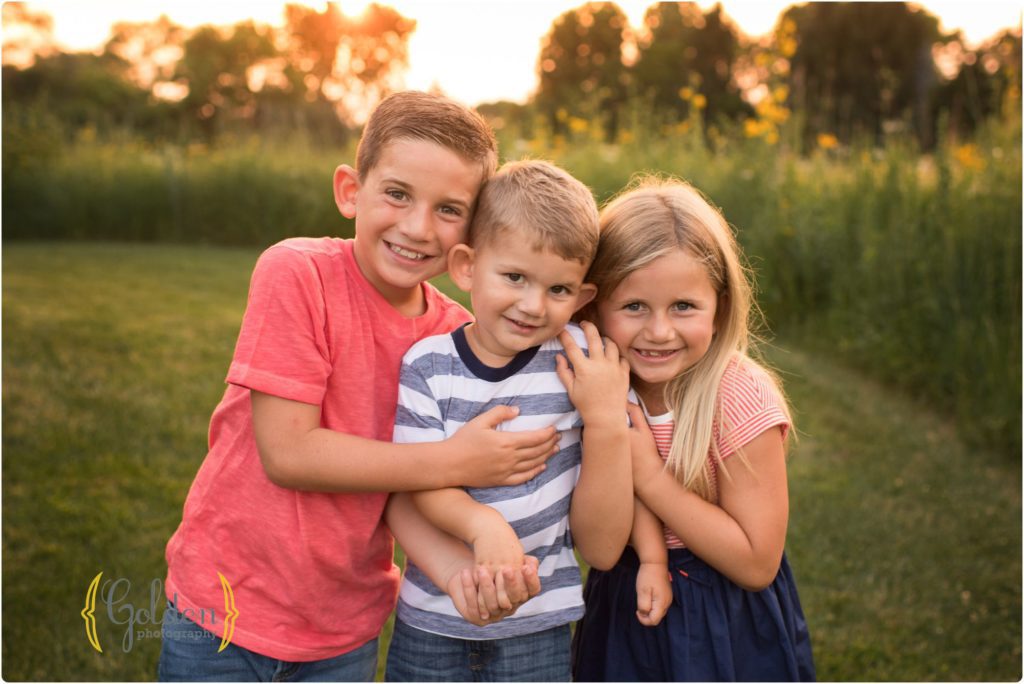 sibling hug each other for outdoor family photos near Lake Zurich IL