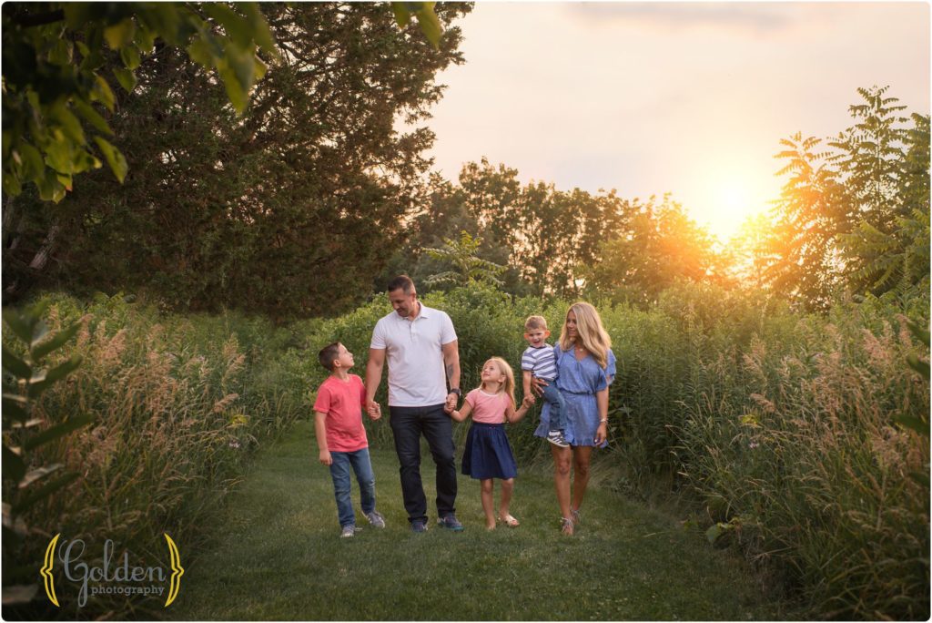 family walks together at sunset with nest family photographer in northwest Chicago suburbs
