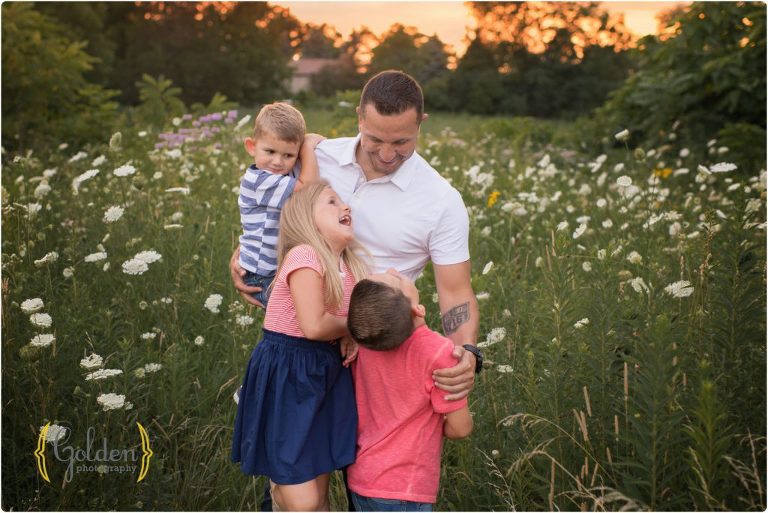 children laugh and hug dad for outdoor family photos near Chicago IL