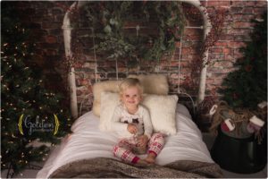 child sits on themed bed for holiday photo session near Chicago IL