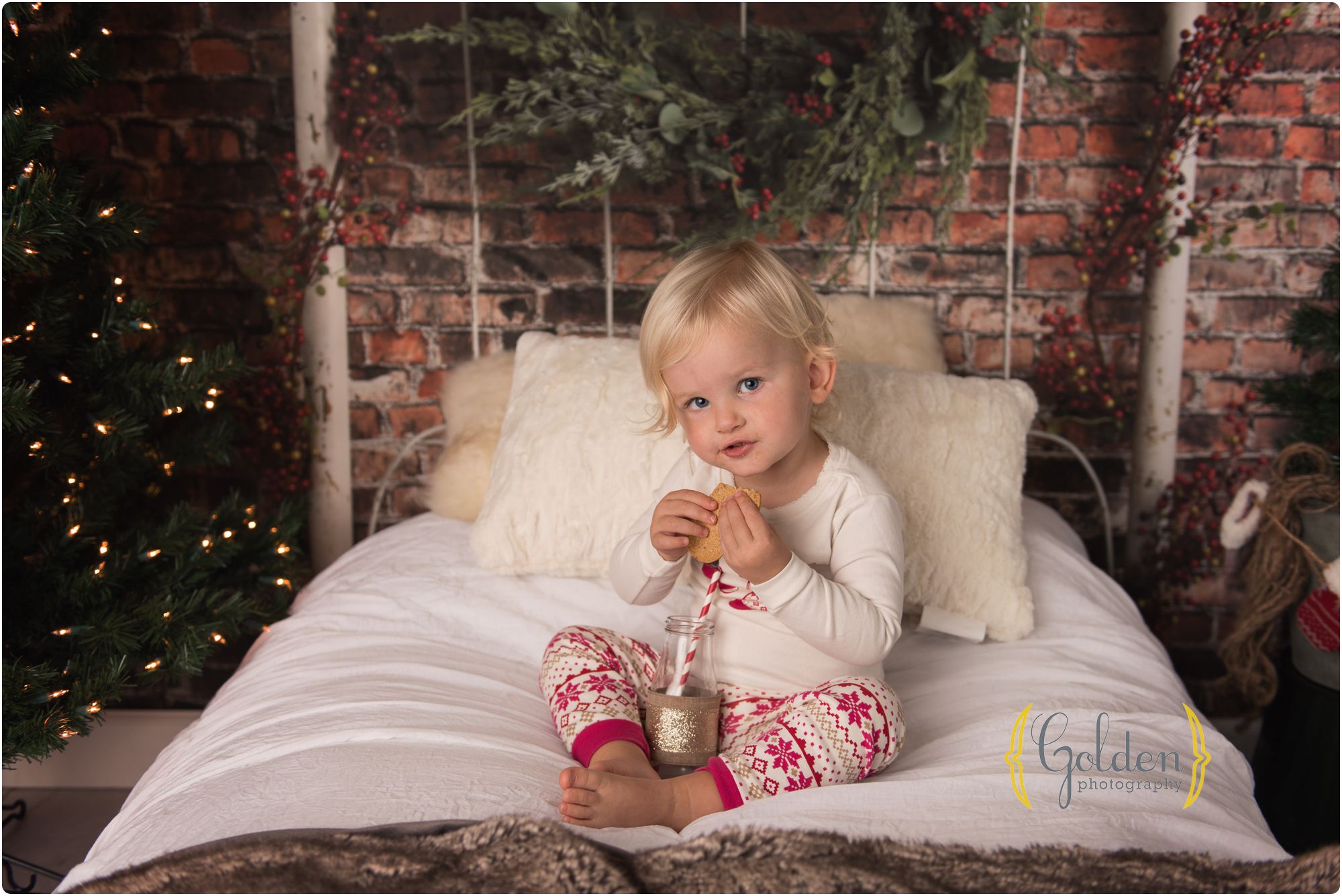 child sits on holiday bed with milk and cookies for photo session