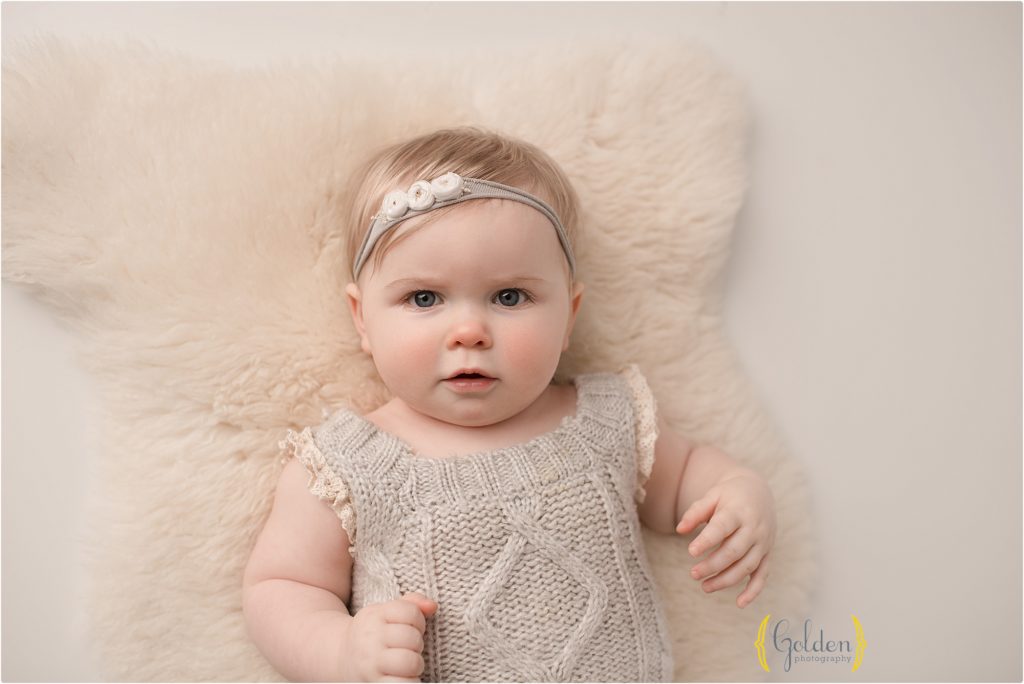 baby girl laying on floor posing for 1 year photos Chicago