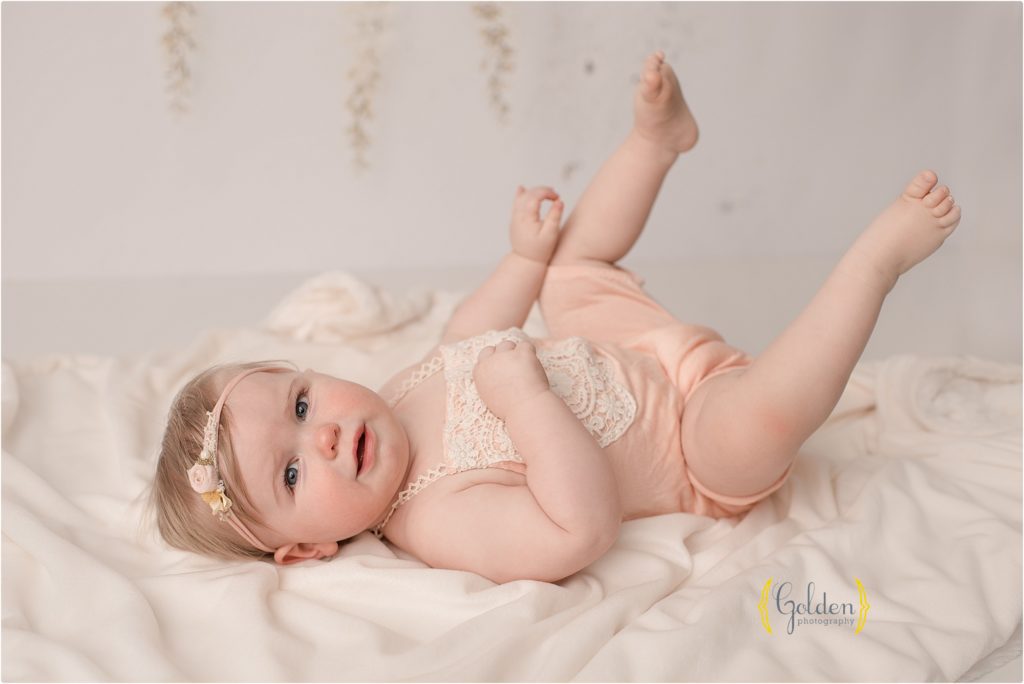 baby girl laying down for birthday photos in northwest Chicago suburbs