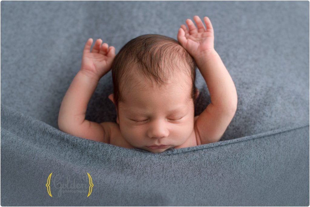 baby boy sleeping with arms up with best Lake County IL newborn photographer