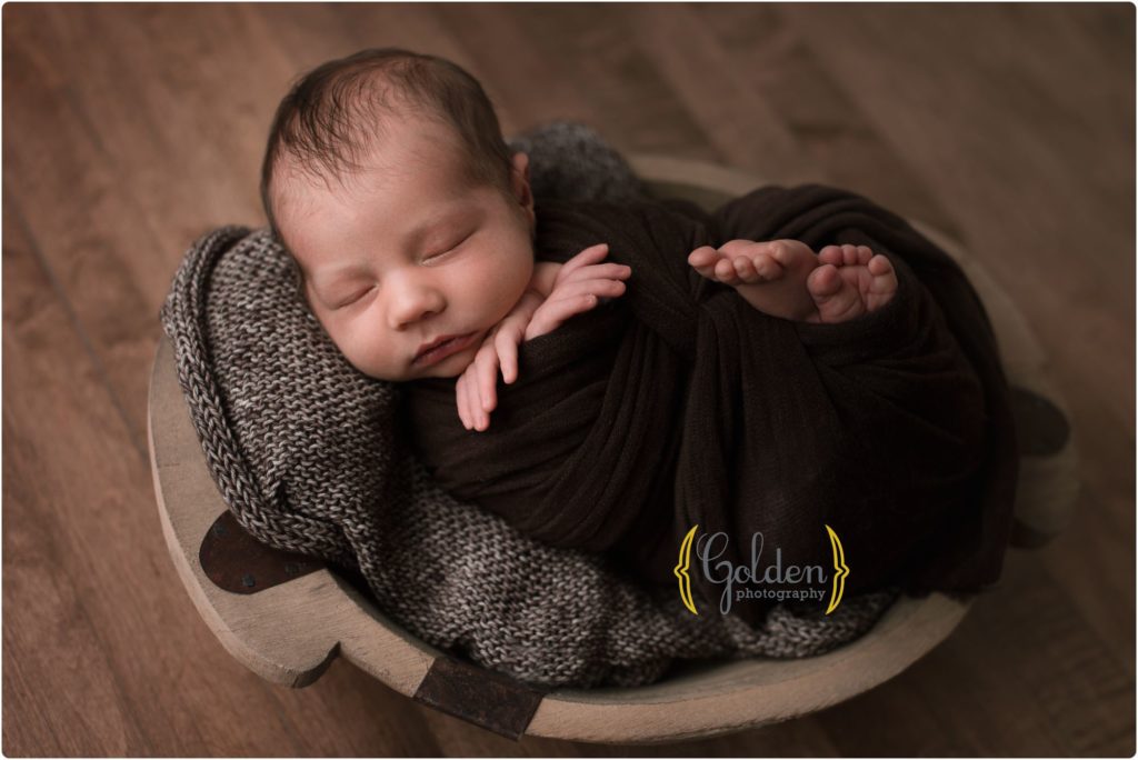 baby boy wrapped in brown sleeping for newborn photos in Lake County IL