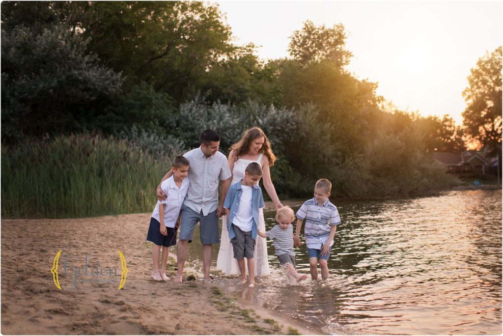 parents posed with their four sons on a beach for family photographs near Palatine IL