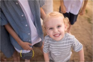 little boy looking up at photographer during family beach photos in lake Zurich IL