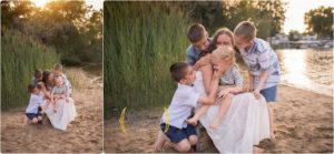 mom sitting on a beach with her four boys during outdoor family photos in Lake County IL