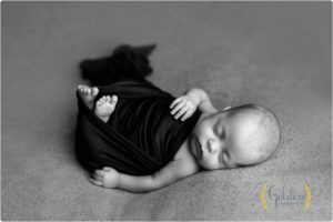 baby loosely swaddled and sleeping with best newborn photographer near Chicago IL