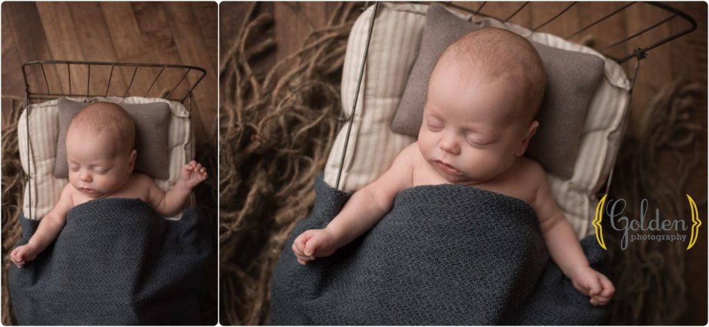 baby boy on small bed in Chicago baby photo studio