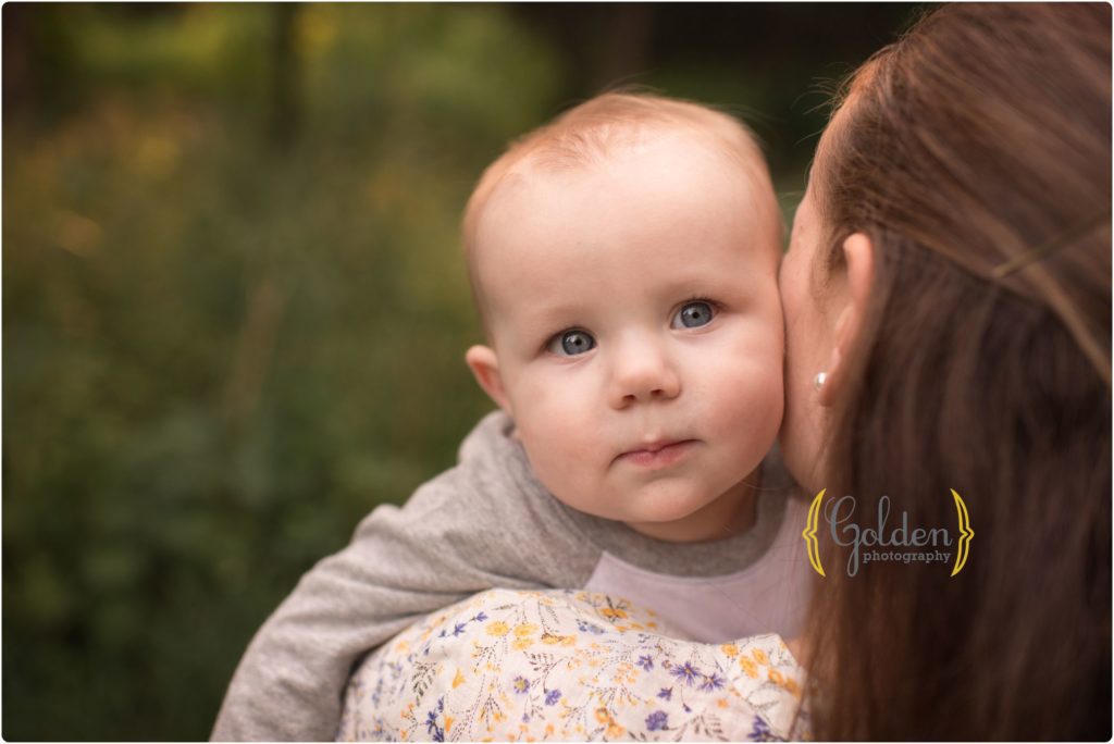 little boy snuggling with mom for outdoor family photo session near Barrington IL