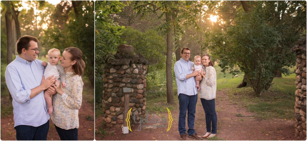 family of three posing together by stone columns for family photographs in a park near Chicago IL