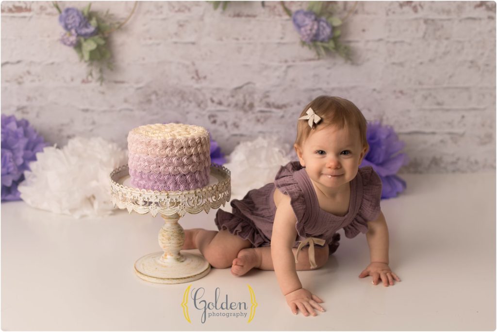 1 year old posing with cake in Barrington photo studio