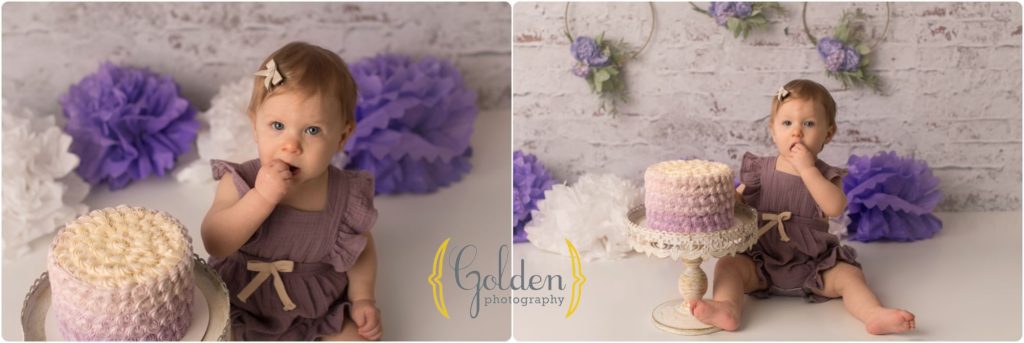 girl eating first birthday cake during photo session