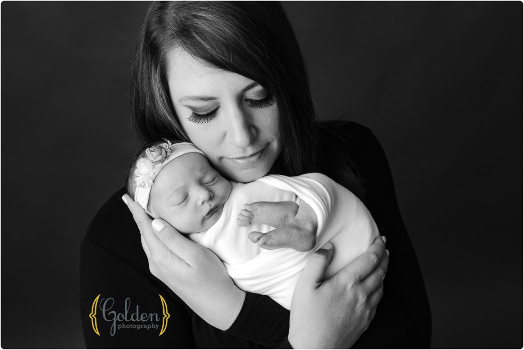 portrait of mom holding newborn baby girl