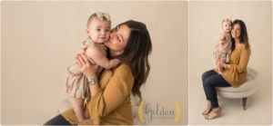 mom holding 1 year old daughter in photo studio