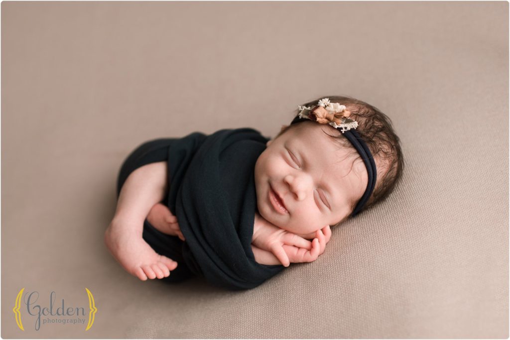 neworn girl smiling wrapped in blue