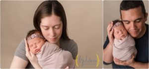parents holding newborn daughter in photo studio