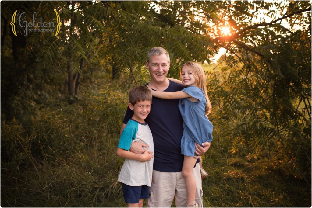 dad holds son and daughter during family photo session