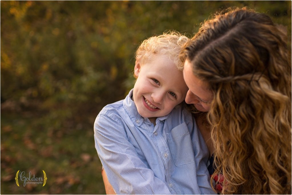 boy snuggling with mom for family photos outside Chicago IL