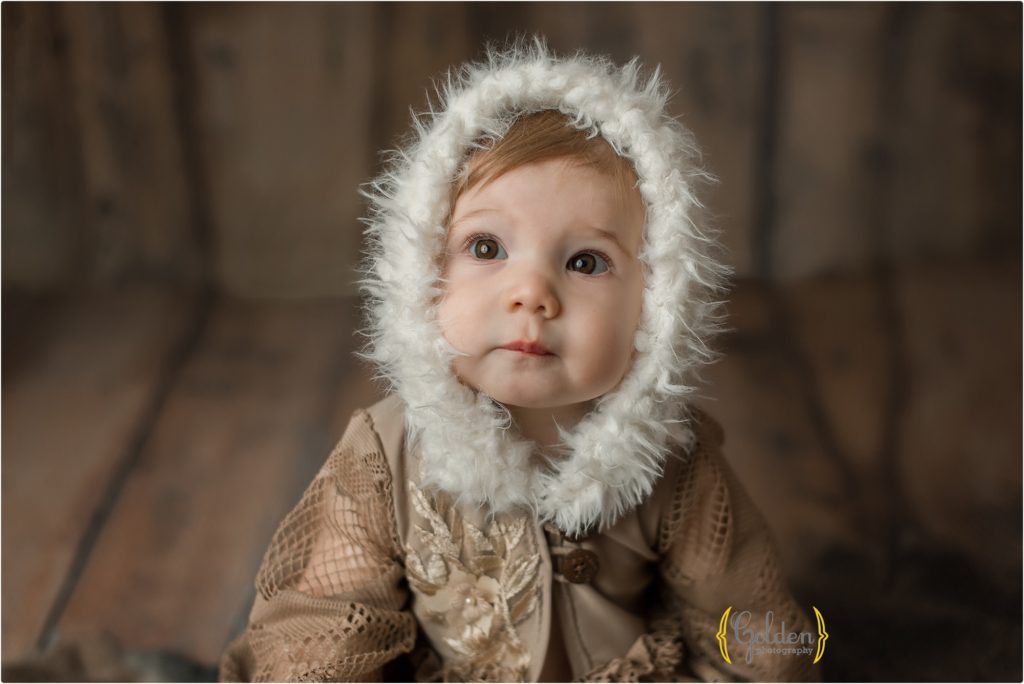 six month old child wearing hooded outfit in Lake Zurich IL photo studio