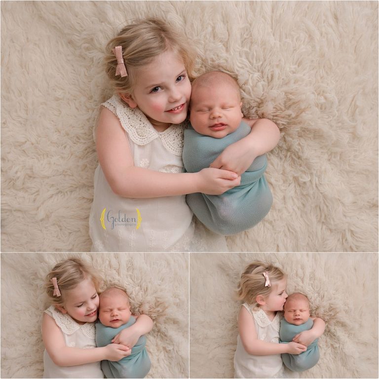 sister cuddling with baby brother for photo session in Lake County IL