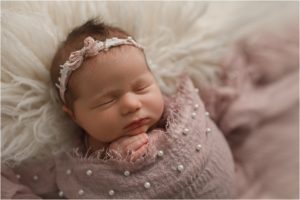 baby girl asleep under pink blanket on white rug near Vernon Hills IL