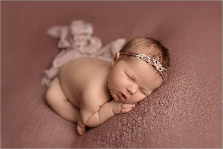 baby girl asleep on pink cloth in photo studio near Vernon Hills IL