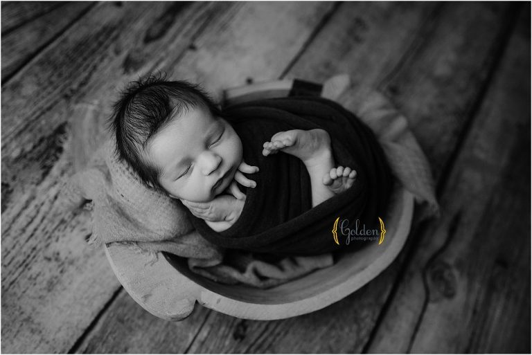 black and white of sleeping baby wrapped in a bowl with Arlington Heights newborn photographer