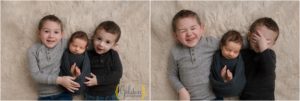 big brothers laying down and holding baby brother for photo session