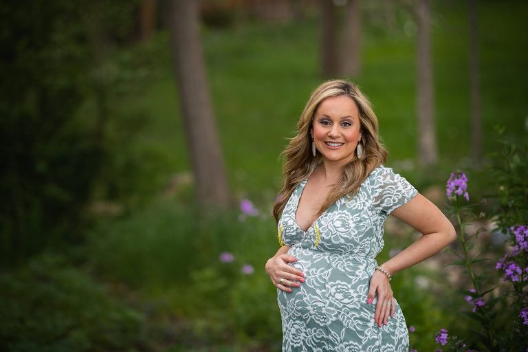 mom holding pregnant belly during springtime photo shoot