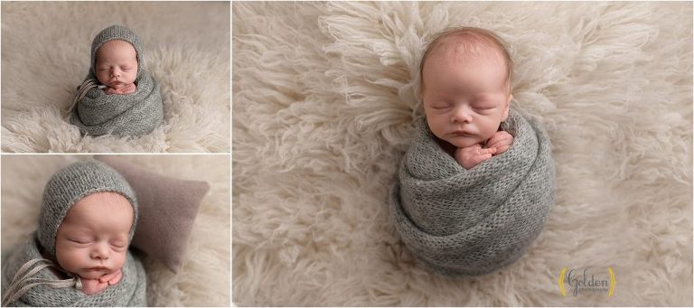 swaddled baby boy on white rug during photo session