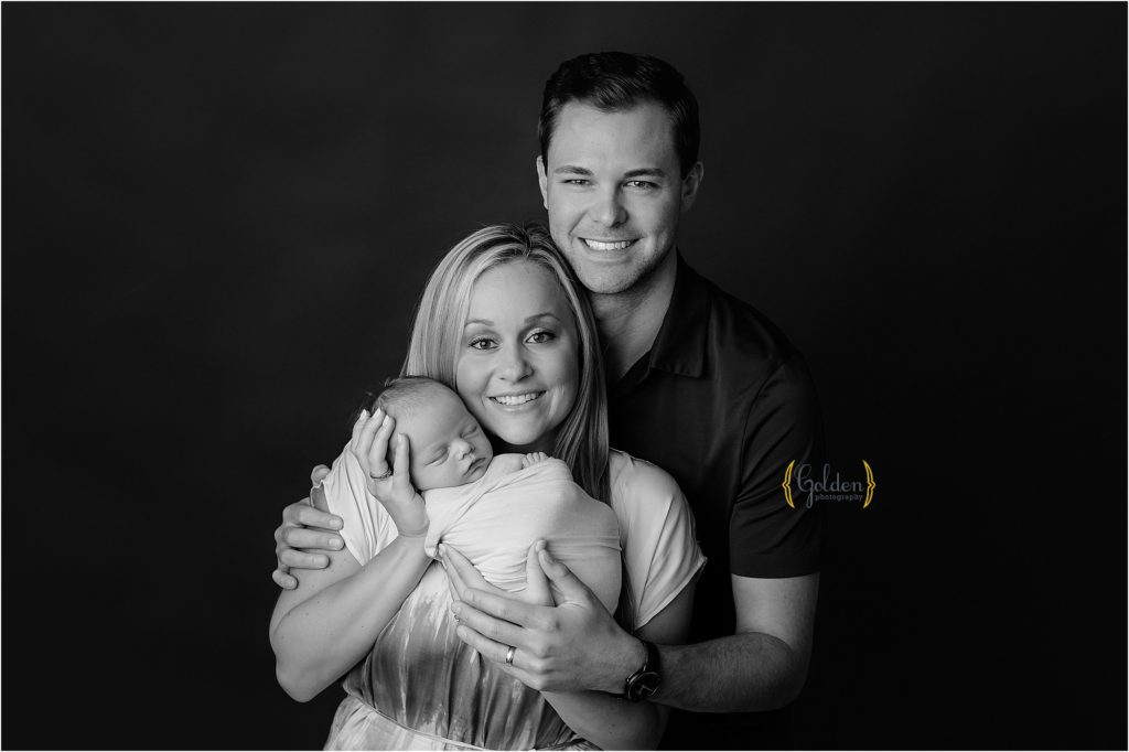 black and white of new family holding baby boy