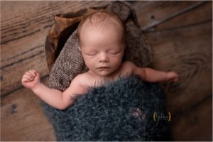 baby boy asleep in wooden bowl in Lake Zurich photography studio
