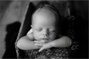 black and white of baby boy in wooden crate